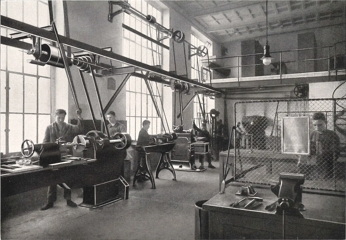 Praktykanci obsługują maszyny w warsztacie obróbki metalu.